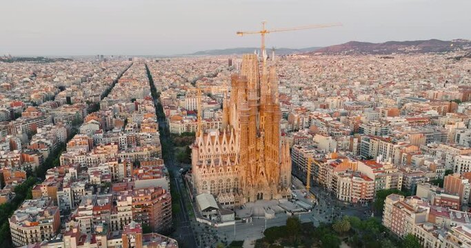 Sagrada Familia Barcelona, Spain Eixample residential area. Architectural heritage of country in summer on sunny day blue sky aerial view slide drone turn. Go Everywhere Travel. UNESCO. Tourism