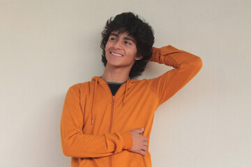 relaxed smiling young man posing on street wall