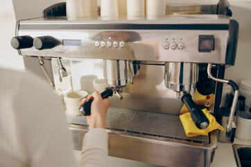 Close up of female barista making coffee in a coffee machine working in cafe. High quality photo