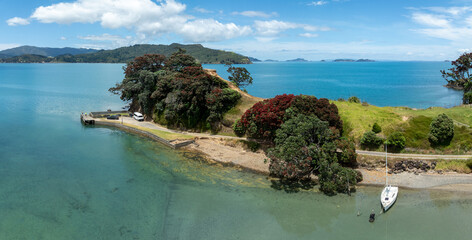 Yatch moored on the beach and headland of Otautu bay, Coromandel, Coromandel Peninsula, New Zealand.