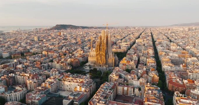 Sagrada Familia Barcelona, Spain April 2023 Eixample residential area Architectural heritage of country at sunrise in summer on sunny day aerial view slide drone turn. Go Everywhere. Travel. UNESCO
