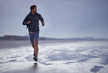 Running, beach and man with vacation, travel and exercise with nature, explore and ocean. Person,...