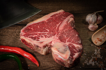Thick Raw T-Bone Steak. Dry-aged Raw T-bone or porterhouse beef meat Steak on cutting boar with...