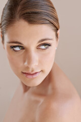Fototapeta premium Face, beauty and skincare of woman in makeup at studio isolated on a brown background. Thinking, serious or young model in cosmetics, healthy glow of aesthetic or spa facial treatment for dermatology