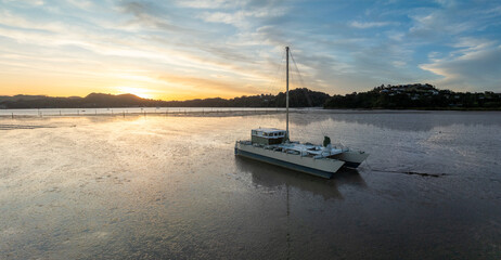 boat resting on mudflats at low tide in the Coromandel, Coromandel Peninsula, New Zealand.