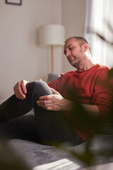 Man with knee pain at home.