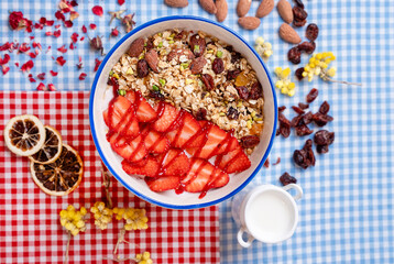 Healthy smoothie bowl with granola, yogurt, berries, oats and nuts on fabric background. Breakfast smoothie bowl, top view.