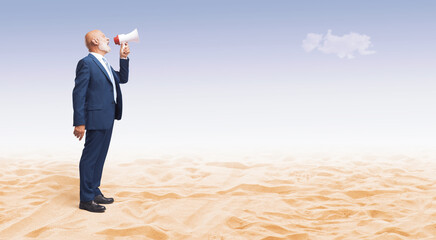 Lonely businessman shouting into a megaphone in the desert