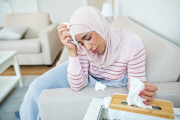 Sick day at home. Young Arabic woman has runny and common cold. Cough. Closeup Of Beautiful Young Woman with hijab Caught Cold Or Flu Illness.