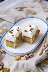Pistachio and raspberry cake served on a fabric background