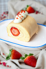 Banana and strawberry roll served on a ceramic plate