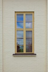Fototapeta na wymiar Closeup of yellow framed wood window on a stone building.