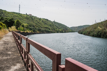 Blurred and perspective of metal fence flanking the Mondego river in Aguieira dam, Penacova PORTUGAL - obrazy, fototapety, plakaty