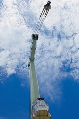 Obraz premium Pier crane against blue sky with clouds.