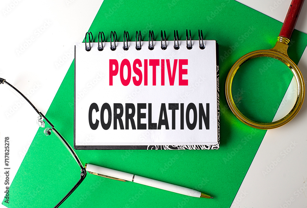 Aufkleber positive correlation text on notebook on green paper