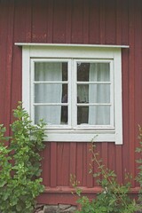 White frame window on red painted wood building.