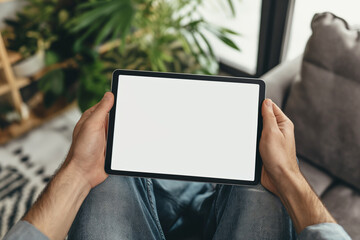 cropped view of man holding digital tablet with blank screen at home