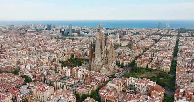 Sagrada Familia aerial view residential area of Barcelona, Spain. Architectural heritage country at sunny day in summer on slide from drone turn. Eixample residential district. Go Everywhere. Travel