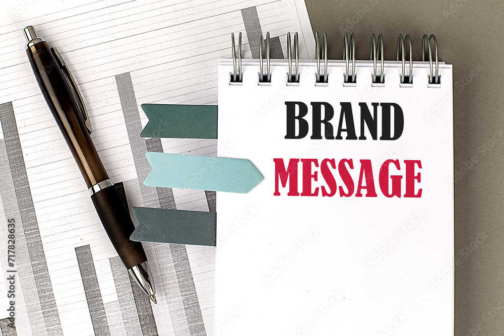 Poster brand message text on notebook with pen, calculator and chart on a grey background