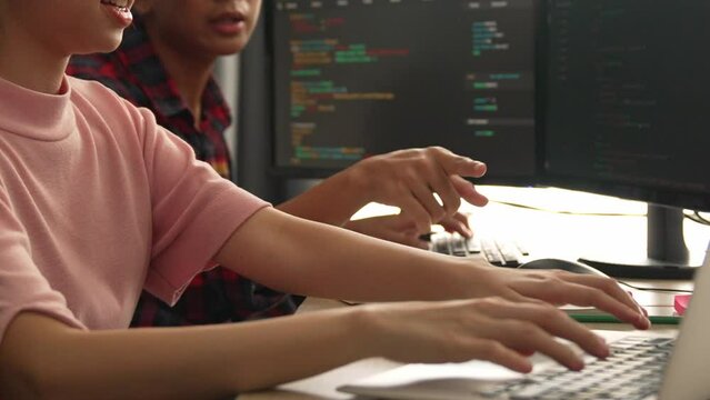 Slow motion back end software developer engineer for computer programming working together on debugging writing computing code, solving complex algorithms display on monitor in office. Burgeoning