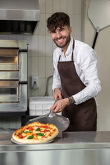 Smiling cooker preparing tasty pizza in pizzeria