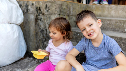 Happy sibilings outdoors having fun eating popcorn.