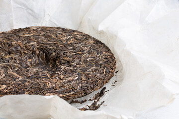 Close-up of round flat disc of puer tea. Pressed Chinese fermented Pu-erh tea.