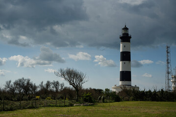 Fototapeta na wymiar Le phare de Chassiron sur l'île d'Oléron en France avec un ciel nuageux.