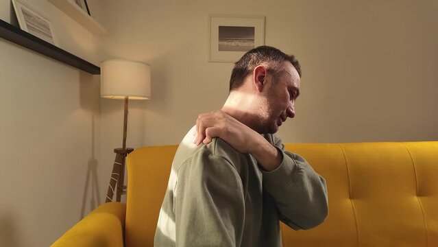 Man with shoulder pain at home.