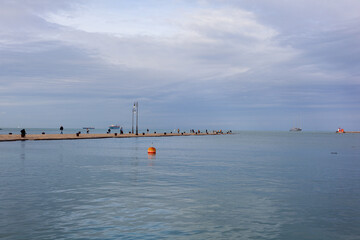 People on The Molo Audace pier of Trieste on a beautiful autumn day