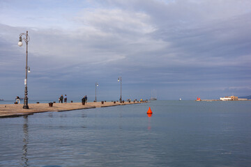 People on The Molo Audace pier of Trieste on a beautiful autumn day