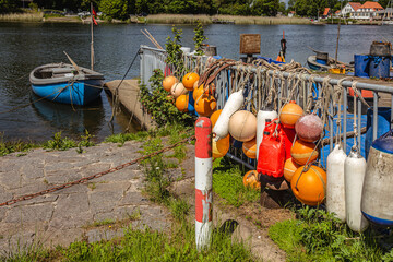 Bunte Bojen eines Fischers mit Boot am Schlei-Ufer - obrazy, fototapety, plakaty