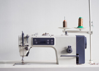 Sewing machine with thread spools on a white background.