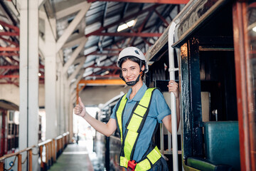 Portrait of woman engineer standing and looking camera in train factory. Maintenance cycle concept.