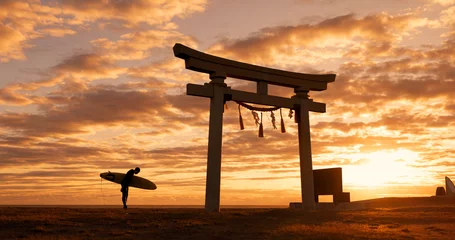 Tuinposter Torii gate, sunset and man with surfboard bowing, ocean and travel adventure in Japan with orange sky. Shinto architecture, Asian culture and calm beach in Japanese nature with person at spiritual mo © Siphosethu Fanti/peopleimages.com