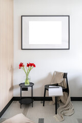 Vertical shot of coffee table with vase, chair against wall with picture