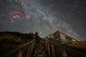 Majestic Night Sky Filled With Stars and Meteors Above Mountain Cabin