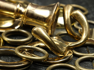 Various household items made of brass and bronze lie on a black board

