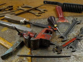 Working and rusty instruments open end wrench, pliers, rasp, bench vice, hammer, awl  lie on the...