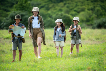 Group family children checking map and walking in the jungle adventure.   Asia people tourism for destination leisure trips for education and relax in nature park.  Travel vacations Concept