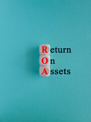 Return on assets symbol. Wooden cubes with the red inscription return on assets on beautiful blue...