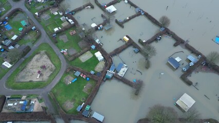 Tilting aerial view of flooded camping site with houses and gardens underwater in Roermond, natural disaster and high water levels in the Netherlands, Europe
