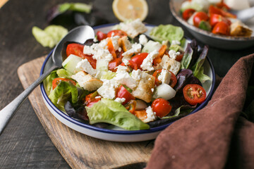 Traditional italian tomato salad panzanella with mozzarella, capers, red onion and croutons. Summer salad. Top view, flat lay