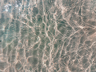 Obraz na płótnie Canvas Blue water surface viewed from above in outdoor sea, sun reflection, dimply. Surface Abstract Background. Clear water in sea with ripple in clean aqua liquid. Summer wallpaper blue background