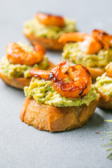 Appetizer canape with shrimp on cutting board on table close up