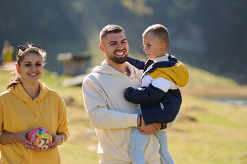 A modern family, along with their son, revels in the joy of a muddy day in nature, running and...