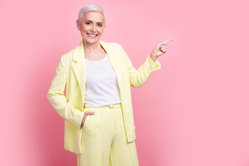Portrait of entrepreneur lady in yellow suit direct finger empty space invite business training school isolated on pink color background