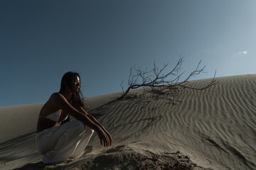 Sexy Asian girl in bikini and pants posing in sand desert