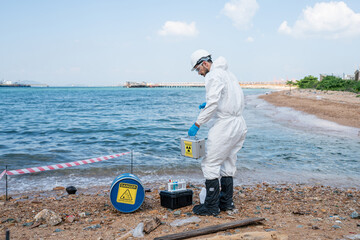 Man Scientists biologists or researchers in protective suits taking water samples from waste water...