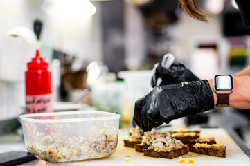 Professional chef cooking forshmak of herring with black bread in restaurant kitchen